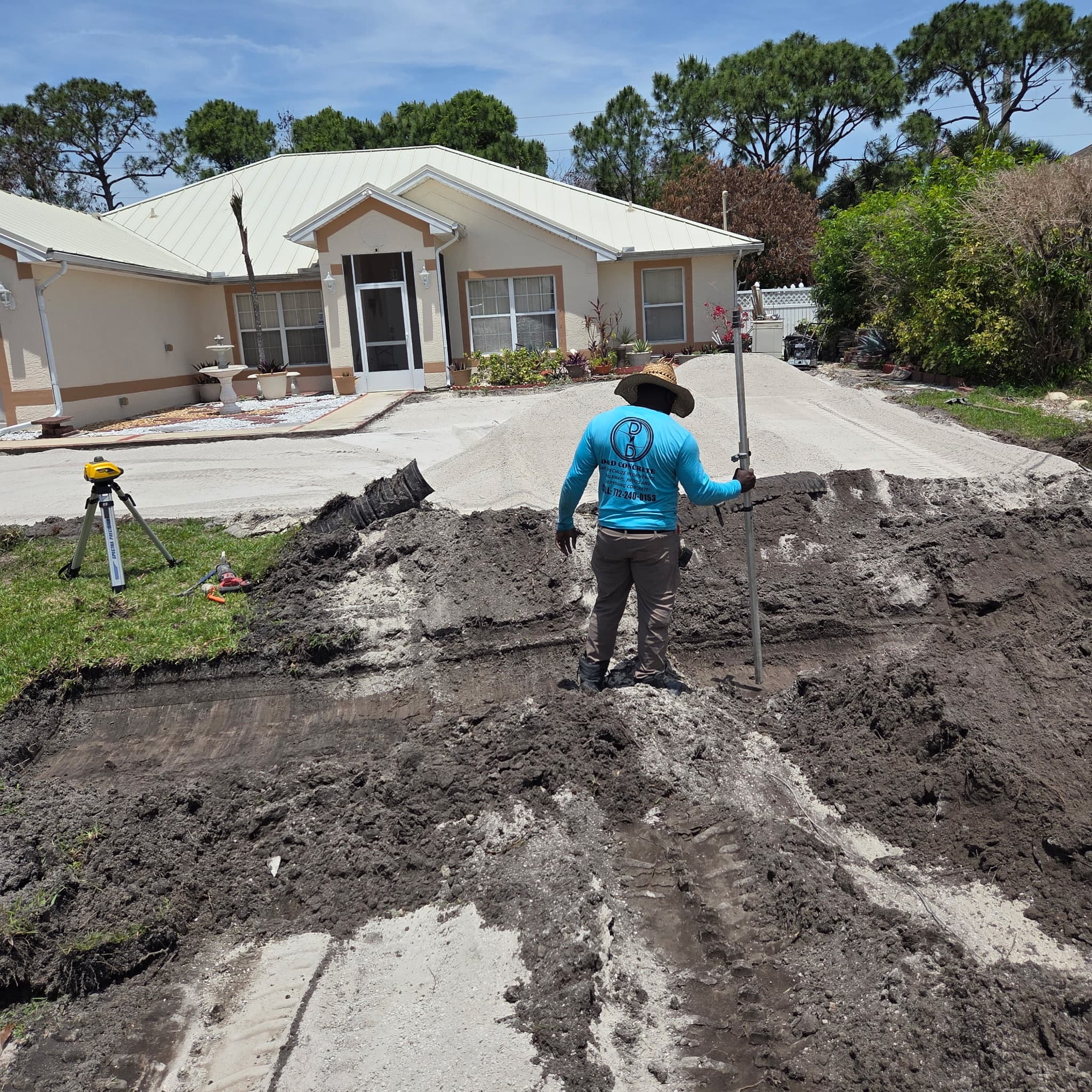 D & D Concrete crew preparing a residential driveway with laser leveling equipment in Port St. Lucie